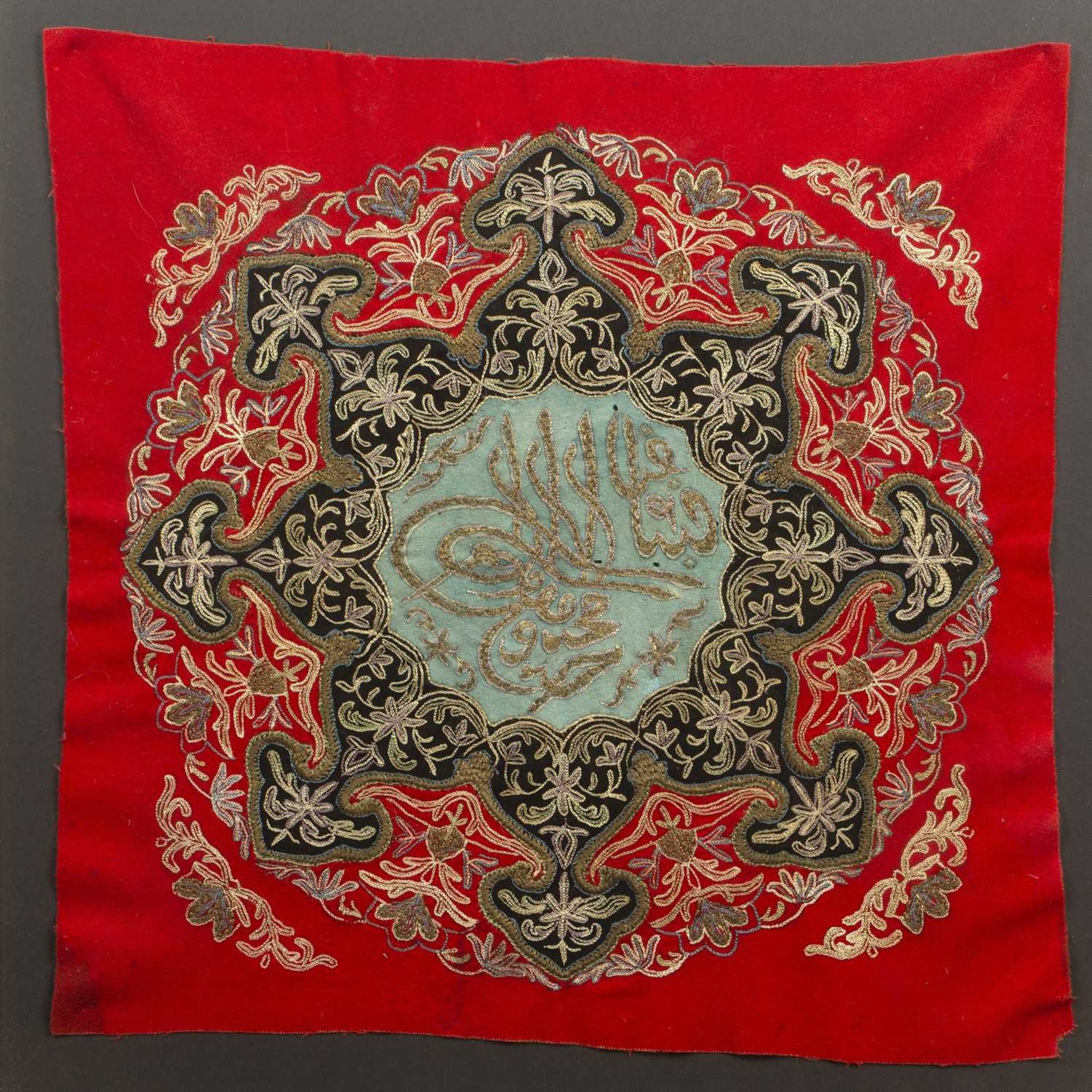 Red ground felt food cover/panel Ottoman the centre with Islamic text, within an embroidered border,