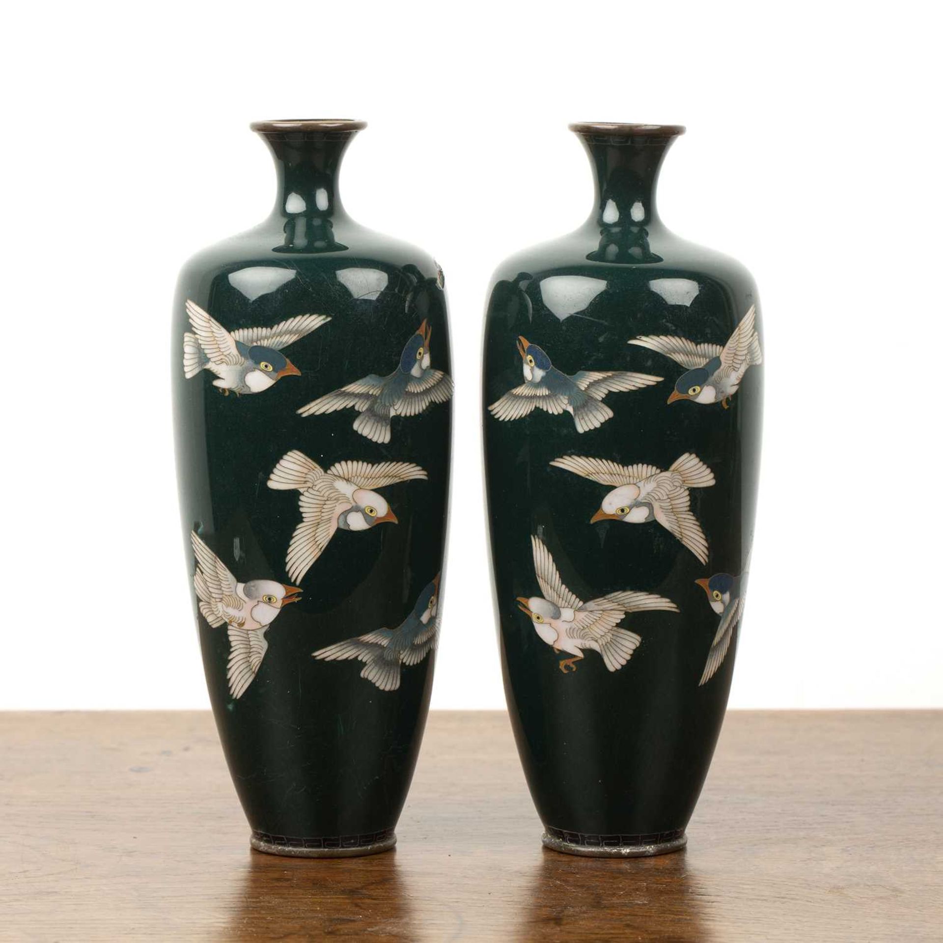 Pair of dark green ground cloisonne vases Japanese, Meiji period decorated with sparrows in flight,