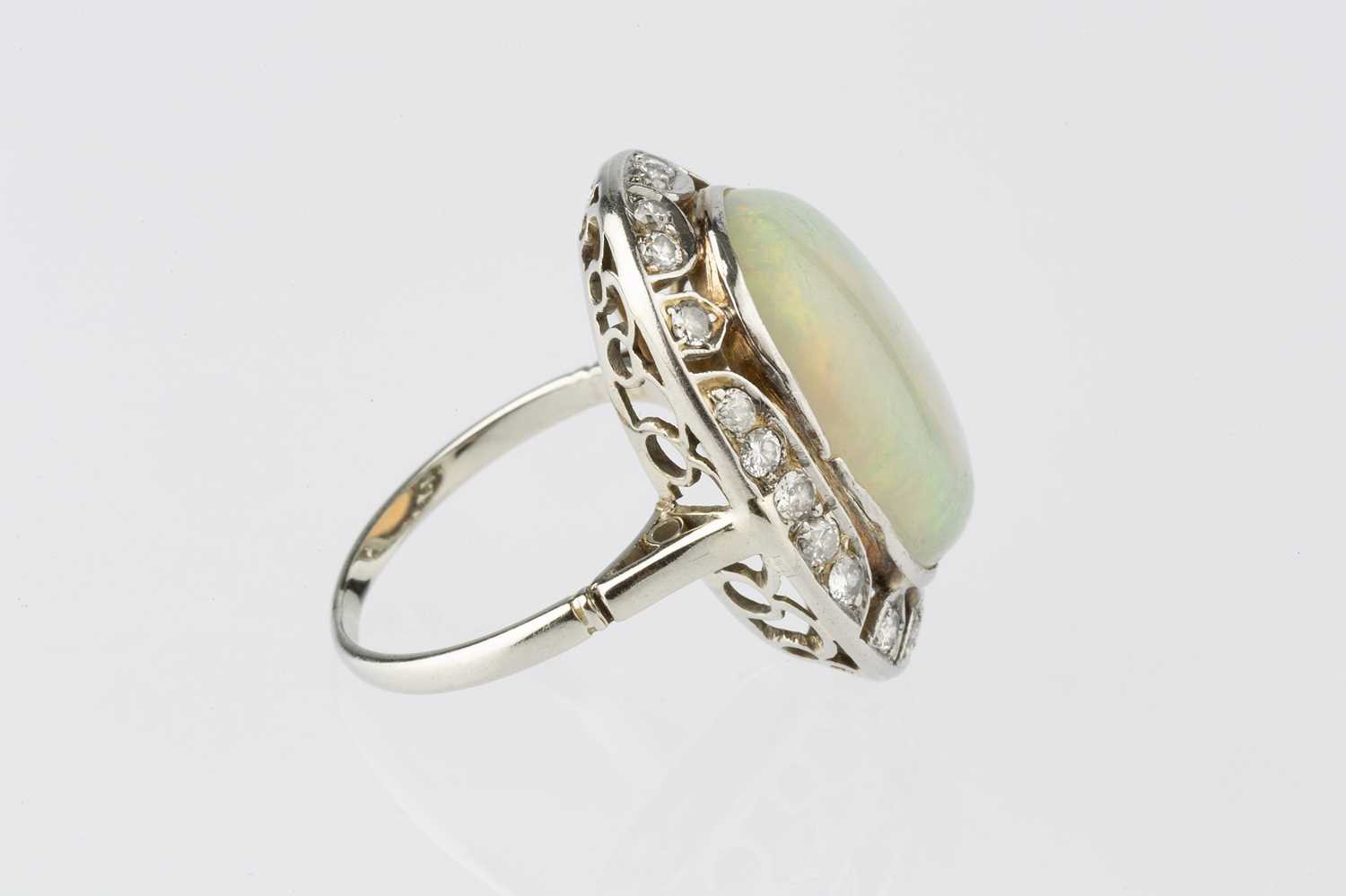 An opal and diamond cluster ring, the oval cabochon opal in collet setting, within an openwork - Image 4 of 10