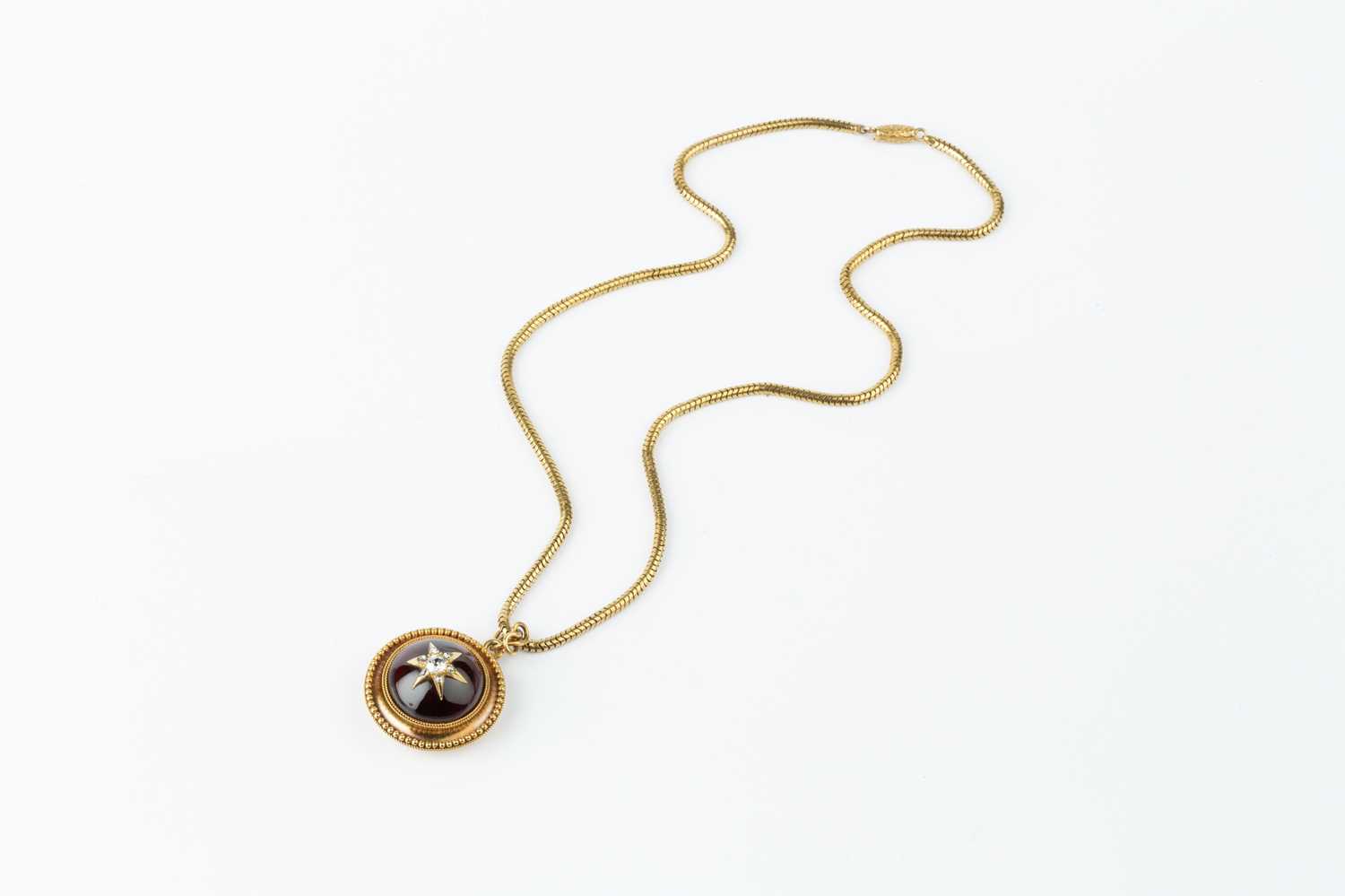 A Victorian garnet and diamond locket pendant on chain, the circular pendant centred with a cabochon - Image 4 of 5