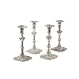 A set of four George II silver candlesticks, with wrythen knopped stems, flared and shaped drip