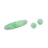 A jade and diamond panel brooch, the elongated shaped oval jadeite panel with pierced and carved