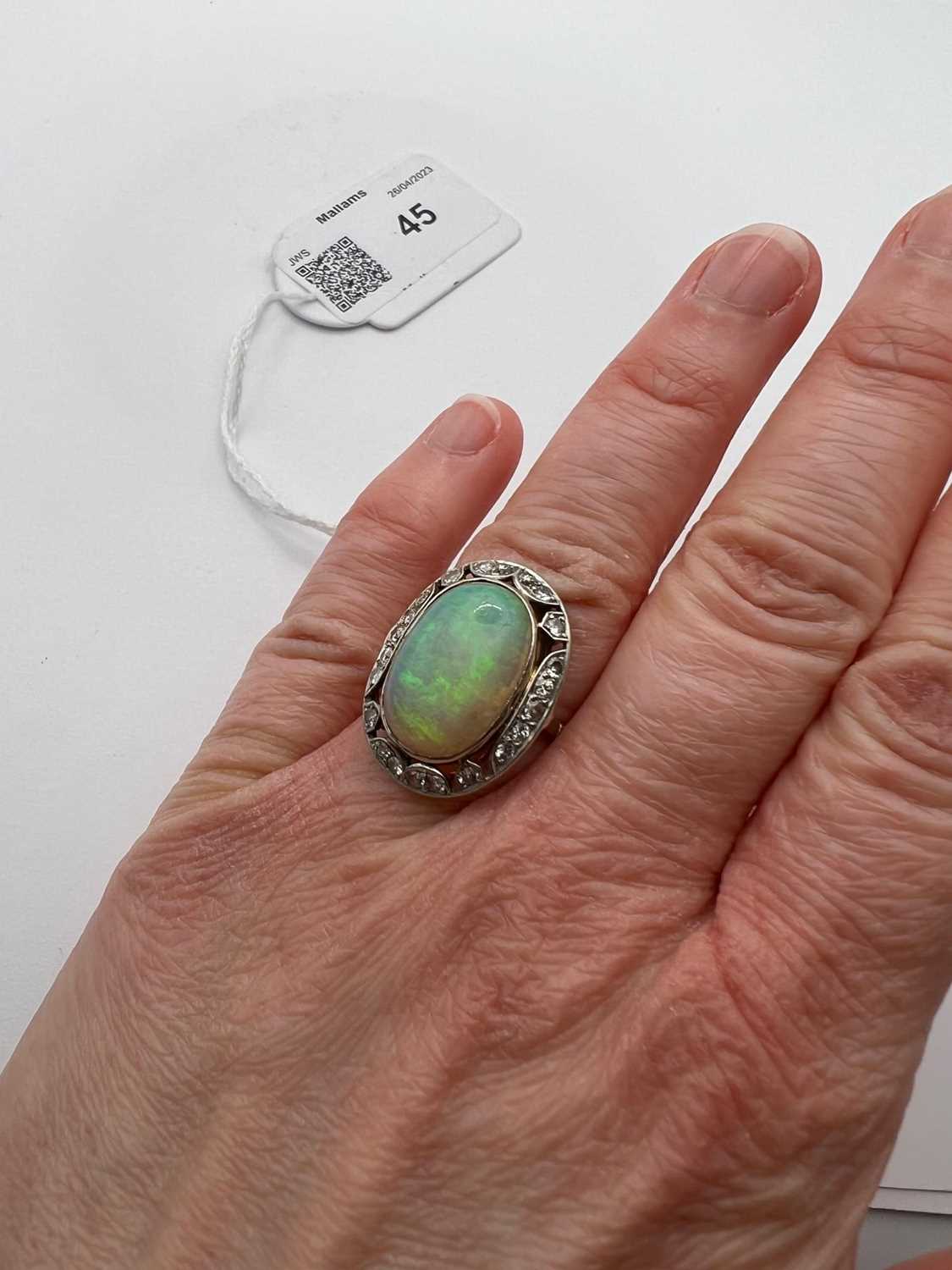 An opal and diamond cluster ring, the oval cabochon opal in collet setting, within an openwork - Image 6 of 10