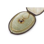 A Victorian garnet and diamond locket pendant on chain, the circular pendant centred with a cabochon