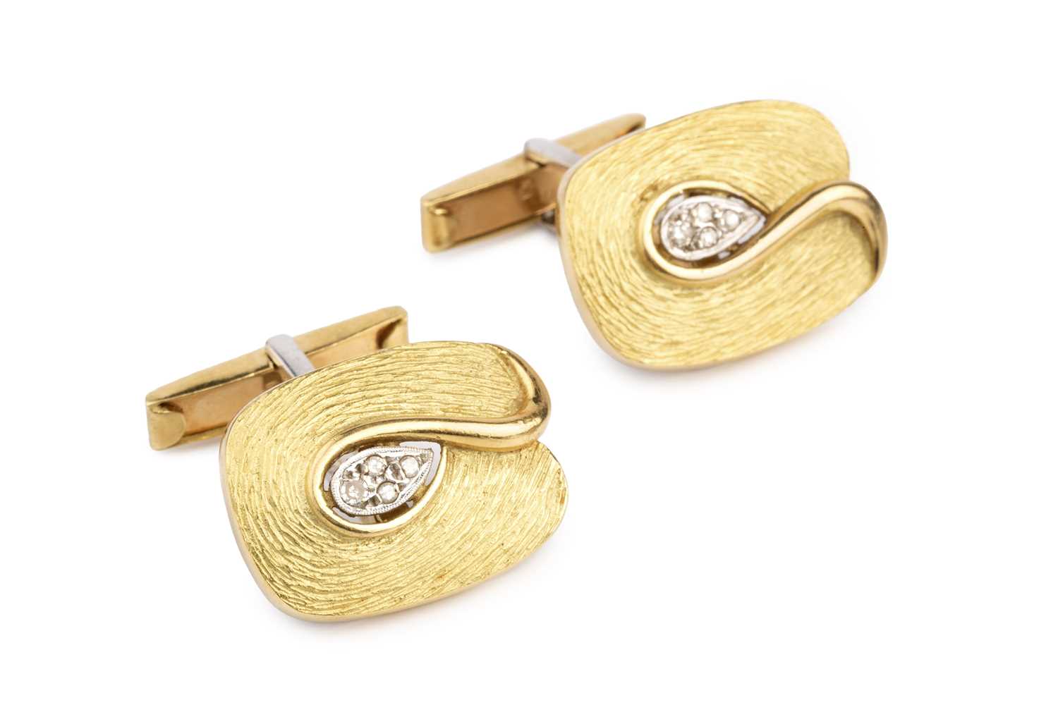 A pair of diamond set cufflinks, each panel designed as an abstract leaf of textured finish, centred