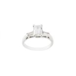 A diamond single stone ring, the emerald-cut diamond claw set between tapered baguette-cut diamond