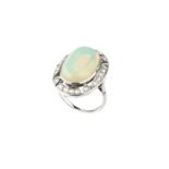An opal and diamond cluster ring, the oval cabochon opal in collet setting, within an openwork