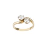 A diamond two stone crossover ring, obliquely claw set with old-cut diamonds, two colour precious