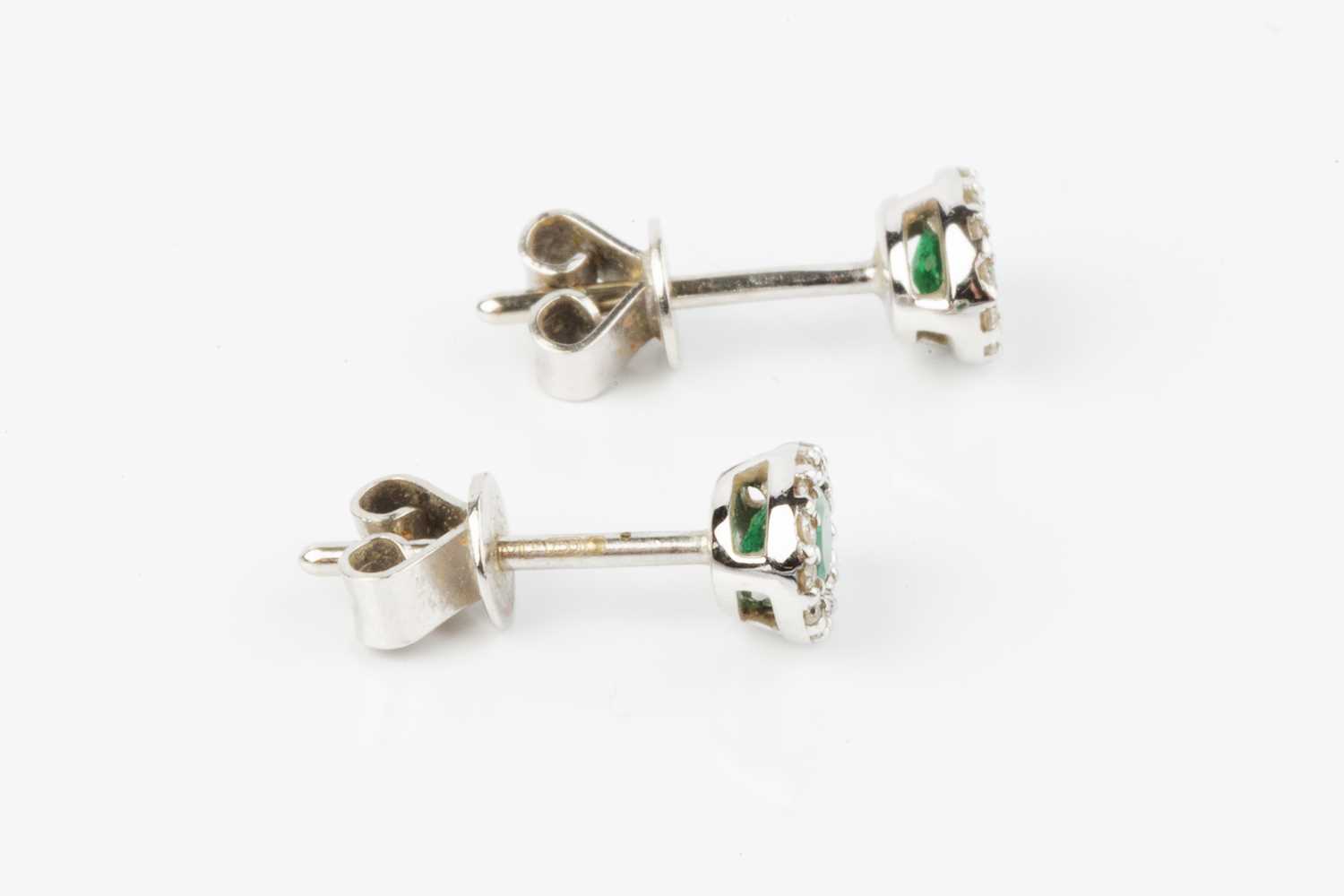 A pair of emerald and diamond cluster ear studs, each oval mixed-cut emerald bordered by round - Image 3 of 3