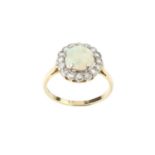 An opal and diamond cluster ring, the slightly oval cabochon opal claw set within a border of