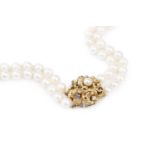 A cultured pearl double strand necklace with gem set clasp, comprising two strands of slightly