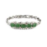 A jade bracelet, the convex articulated frontispiece with a line of five oval jadeite cabochons in