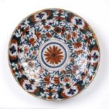 An 18th century Delft charger with red, blue and green foliate decoration, 34cm diameterGlaze loss