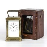 A 19th century French carriage clock with an engraved brass case, enamelled dial with Arabic and