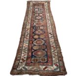 A late 19th century Kurdish woollen runner with polychrome decoration and central Memling guls,