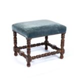 An antique stool with an upholstered seat and bobbin turned supports, 52cm wide x 42cm deep x 41cm