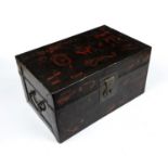 A 19th century Eastern lacquered box with iron ring handles and red lacquered decoration, 41cm