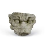 An early medieval English stone carving grotesque head, with a flat cut back. 37cm 25cm 24cm.