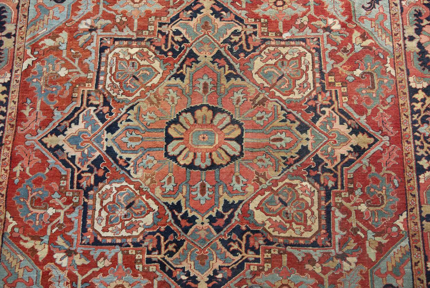 An antique Heriz red ground carpet with geometric decoration 312cm x 412cm old moth damage, - Image 4 of 6