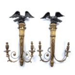 A pair of 19th century Regency style giltwood twin branch wall lights with eagle crests, 35cm wide x