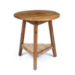 A 19th or early 20th century pine cricket table with circular top, triform base united by a