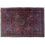 An early to mid 20th century Persian style red and blue ground rug with a banded border and stylised