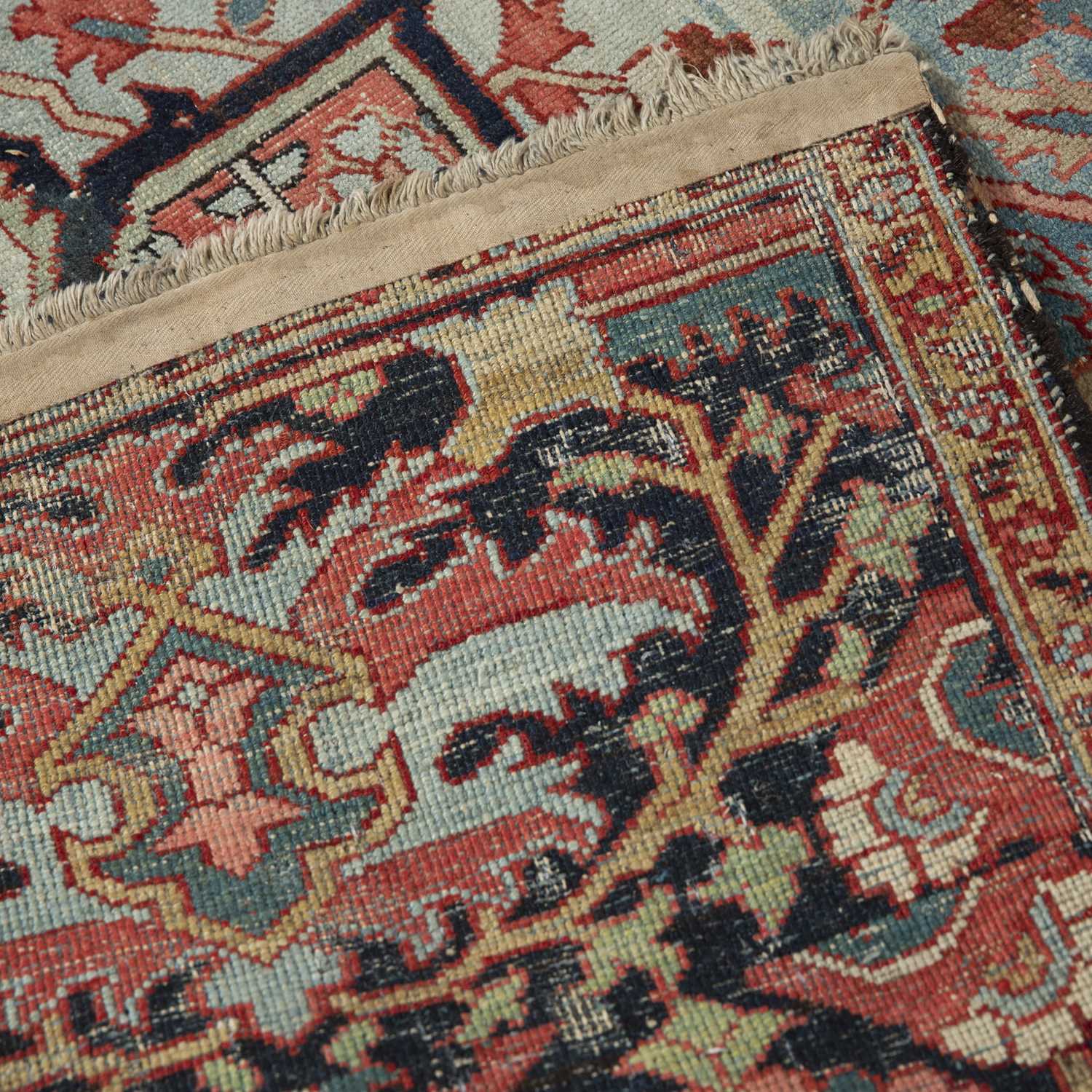 An antique Heriz red ground carpet with geometric decoration 312cm x 412cm old moth damage, - Image 5 of 6