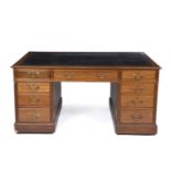 A 19th century Georgian style mahogany partners desk with a black leather inset top, twelve