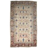 An antique cream ground Khotan rug 123cm x 227cmIn moderate/poor condition with some signs of old