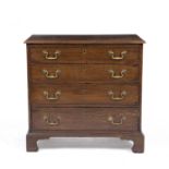 A George III oak chest of four long graduated drawers with brass swan neck handles and raised on