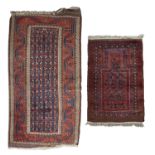 An antique Baluch rug with a blue and red ground and central hexagons, framed by saw tooth patterns,