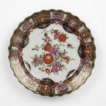 An 18th century Meissen porcelain plate with a wavy boarder and gilded polychrome foliate decoration