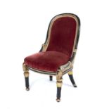 A William IV ebonised and parcel gilt low chair with an upholstered seat, turned and reeded legs,