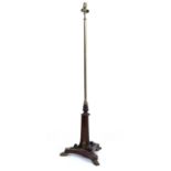 A Regency brass and rosewood adjustable standard lamp with a triform base and gilt metal paw feet,