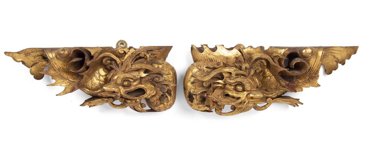 A near pair late 19th/ early 20th century Chinese gilded hardwood wall brackets of dragon form