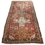 A Persian Karabagh red ground rug with stylised geometric and animal decoration, 148cm x 315cmIn