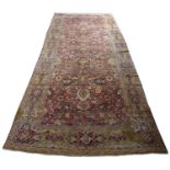 An antique Persian red and yellow ground carpet with foliate decoration, 212cm x 492cmModerate wear,