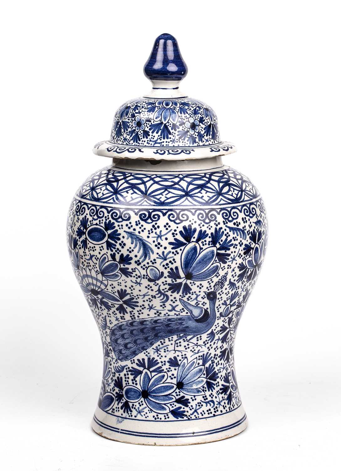 A 19th century Dutch Delft blue and white vase and cover of baluster form with foliate and peacock