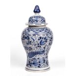 A 19th century Dutch Delft blue and white vase and cover of baluster form with foliate and peacock