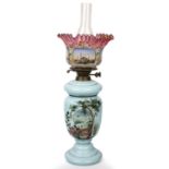 A 19th century blue glass oil lamp the cranberry glass shade with painted decoration. 53cm high