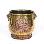 An early Victorian brass and copper log bin with lion's mask ring handles and embossed copper coat