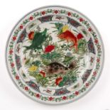 A Chinese porcelain famille verte charger decorated with fish and having a kangxi mark to the