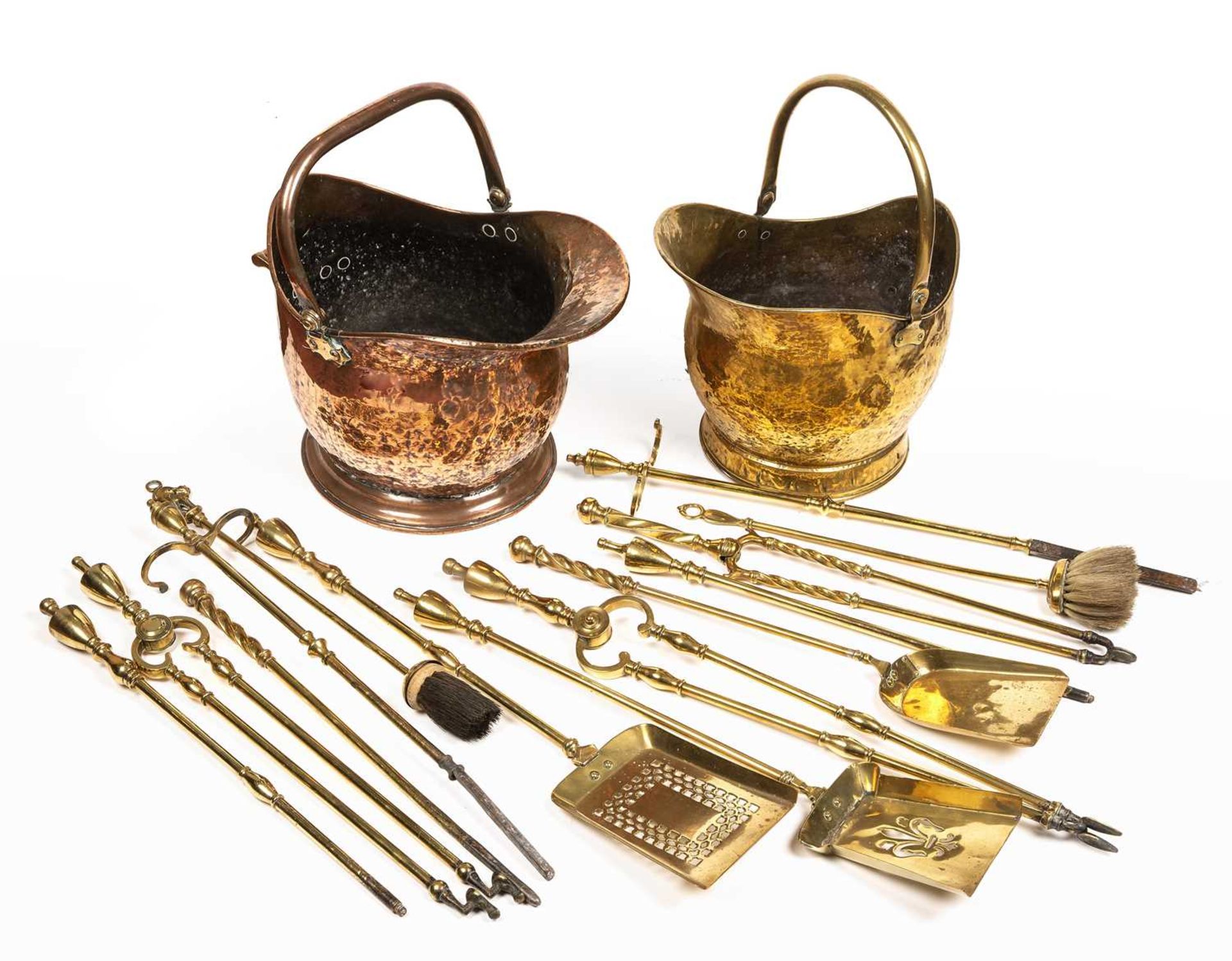 A 19th century copper coal scuttle, a brass coal scuttle and two sets of 19th century brass fire