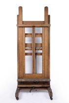 A large early 20th century studio artists easel with adjustable height with four large wooden