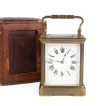 A French brass carriage clock with an enamelled dial and roman numerals 9cm wide 12.5cm high with