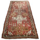 A Persian Karabagh red ground rug with stylised geometric and animal decoration, 148cm x 315cm In