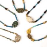 Five Egyptian scarabs with hieroglyphics all strung with beads, the largest 2cm x 1.2cm. From a
