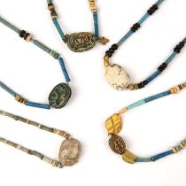 Five Egyptian scarabs with hieroglyphics all strung with beads, the largest 2cm x 1.2cm. From a