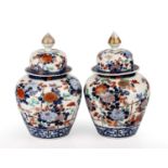 A pair of 19th century Japanese Imari vase and covers. 19cm wide 30cm high. one cover glued cracks