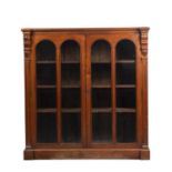 A Victorian mahogany bookcase with twin glazed doors and a plinth base 117cm wide x 38cm deep x